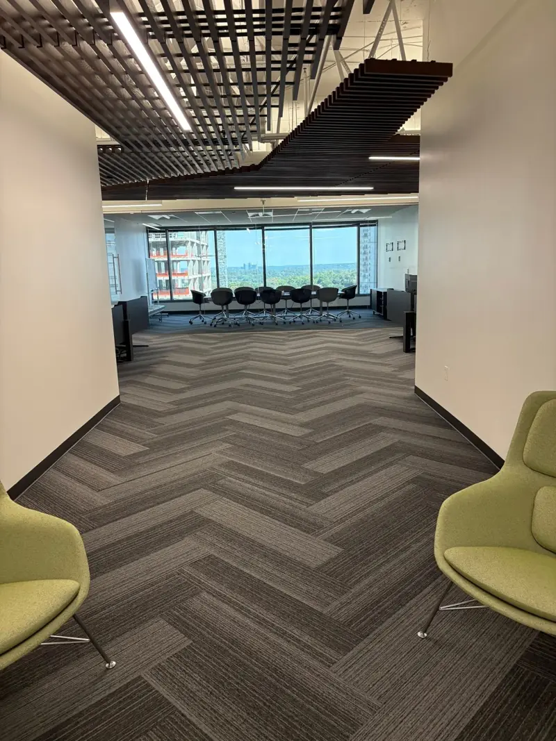 Office floor with herringbone carpet and glass boardroom